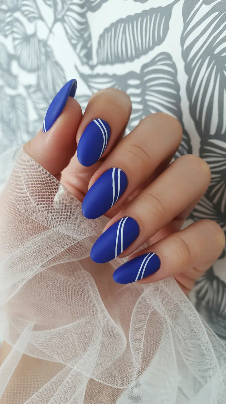 vacation nails trend 2026 Matte Ocean Blue Almond with Minimalist White Lines