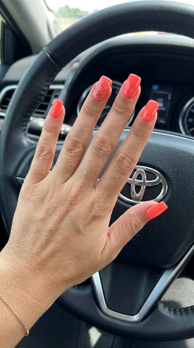 Vibrant coral glitter accent nails for summer vacation and festivals. June nails ideas - best for summer 2026.