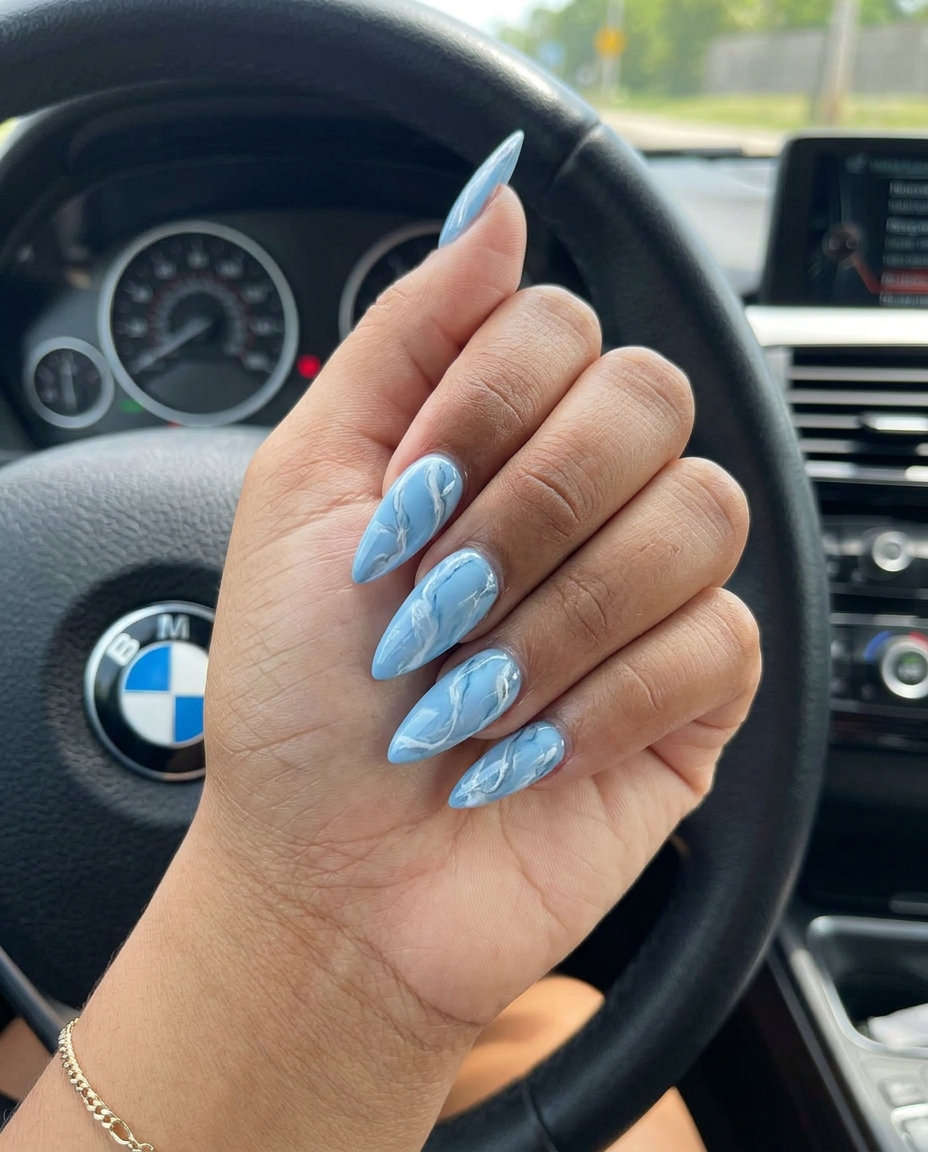 Light Blue Marble Swirls Long Stiletto nails: elegant simple summer acrylic nail designs 2026 for events.