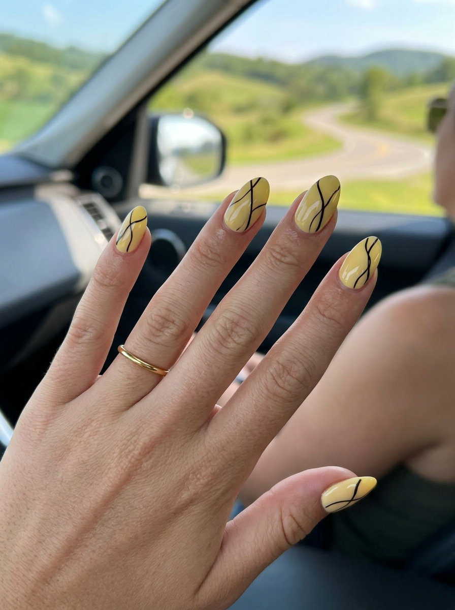 Butter Yellow Abstract Nails 2026: Casual Chic Butter yellow abstract line almond nails 2026 for casual weekend chic. Matte black lines on glossy finish.