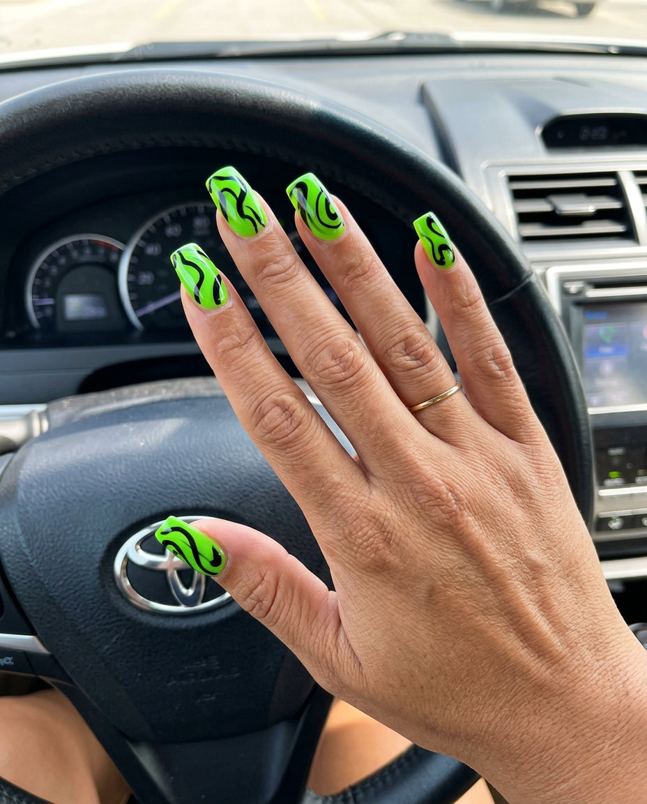 Vibrant lime green nails with edgy black abstract swirls for summer holiday nails 2026. Perfect for festivals.
