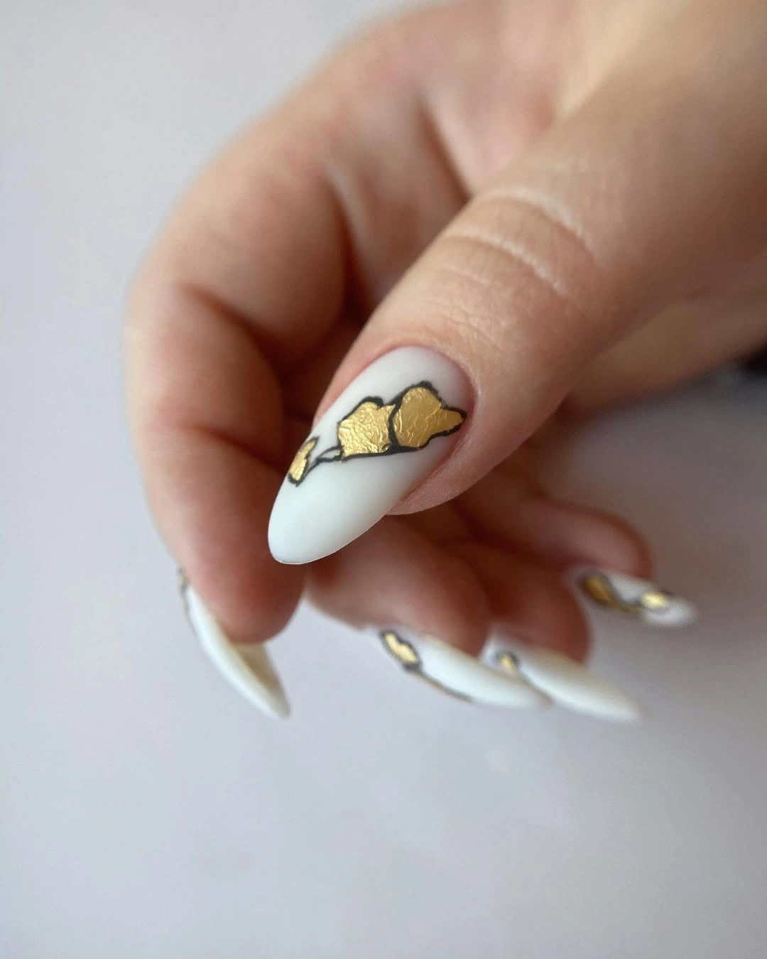 white almond nails with abstract gold outlined accents