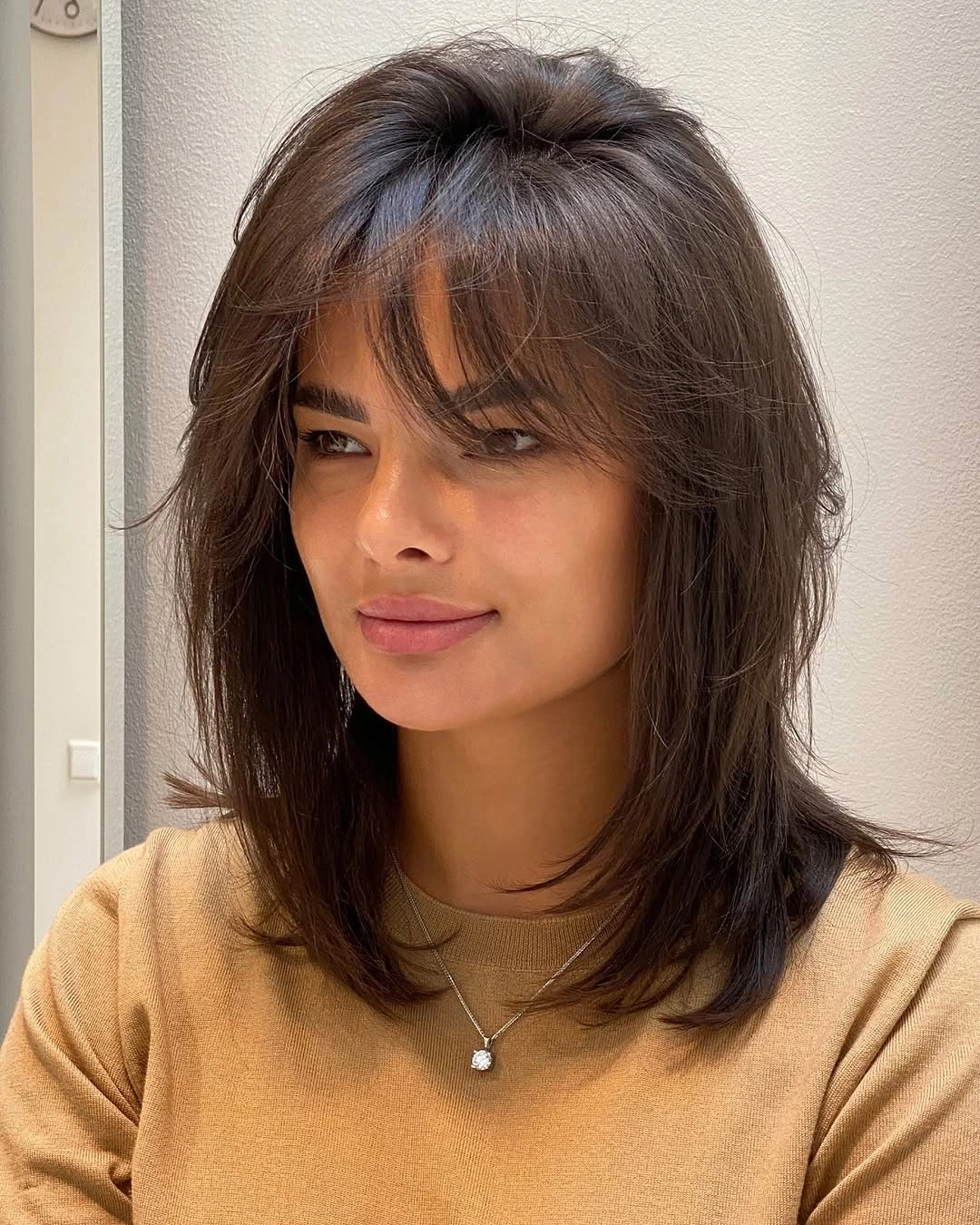 fall haircuts for women 2026 Textured Midi Cut With Wispy Air Bangs
