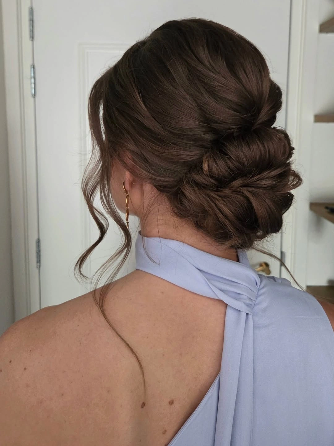 Fall hairstyles for wedding guests 2026 Elegant Twisted Low Chignon with Soft Face-Framing Waves