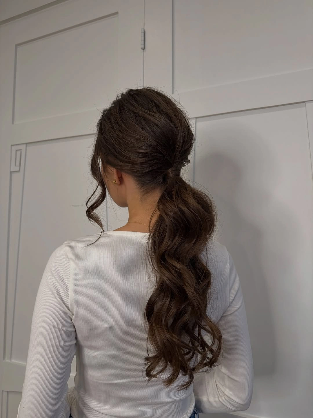 Fall hairstyles for wedding guests 2026 Romantic Low Ponytail with Cascading Soft Waves