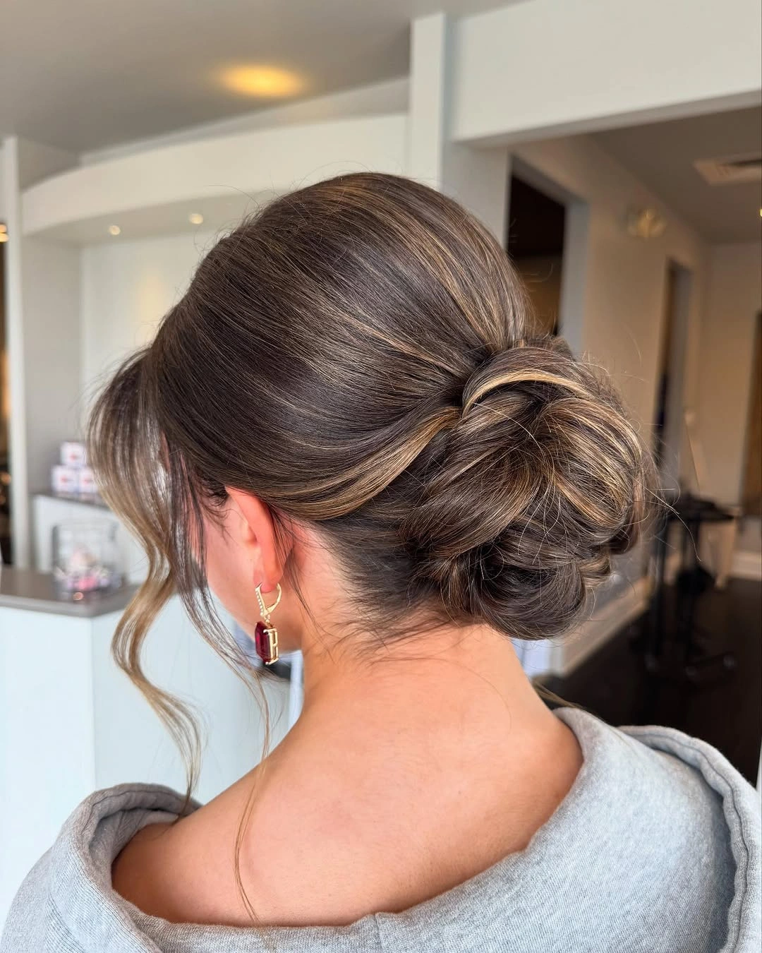 Fall hairstyles for wedding guests 2026 Textured Low Bun with Dimensional Brunette Highlights
