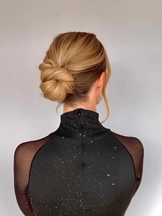 Fall hairstyles for wedding guests 2026 Classic Sleek Chignon with Wrapped Knot Detail
