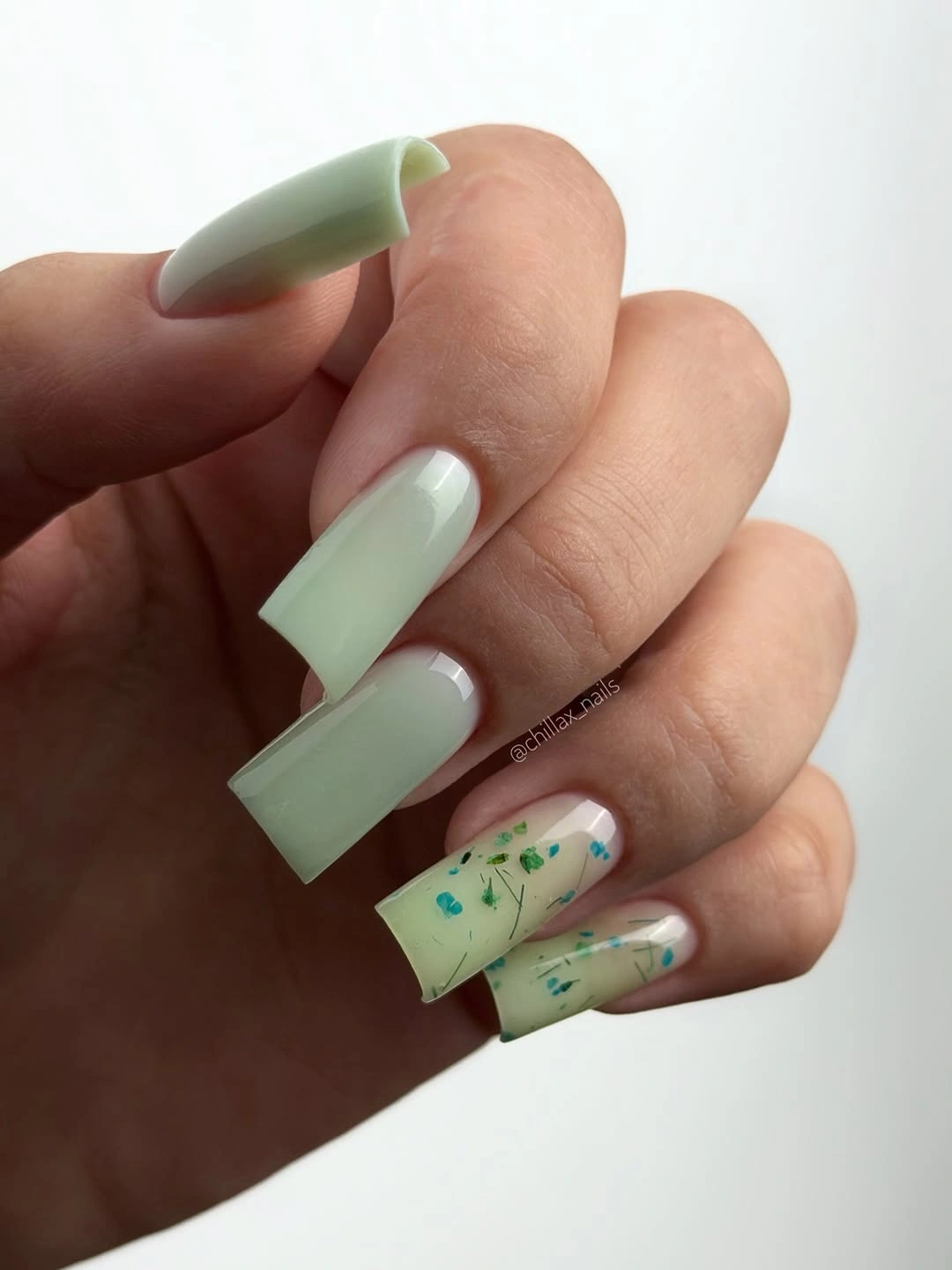 mint square nails with pale accents and tiny colorful flecks