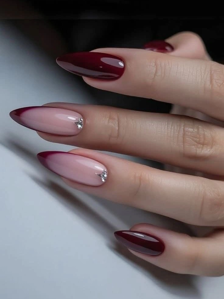 almond nails with burgundy french curves and sheer pink centers