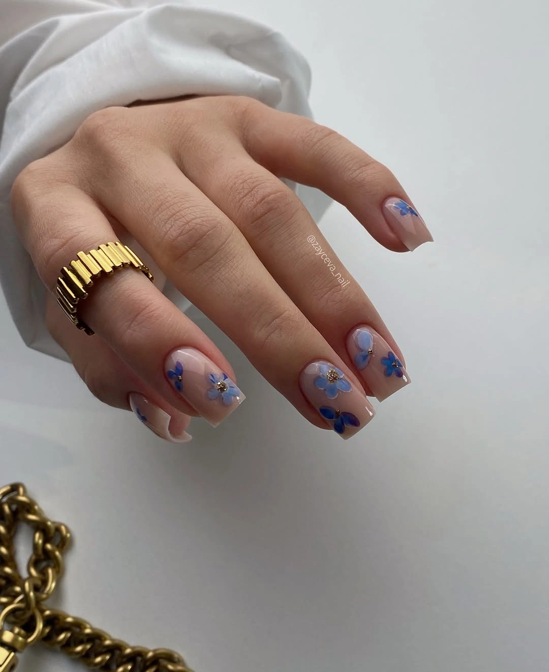 nude short nails with tiny blue flowers and dot accents