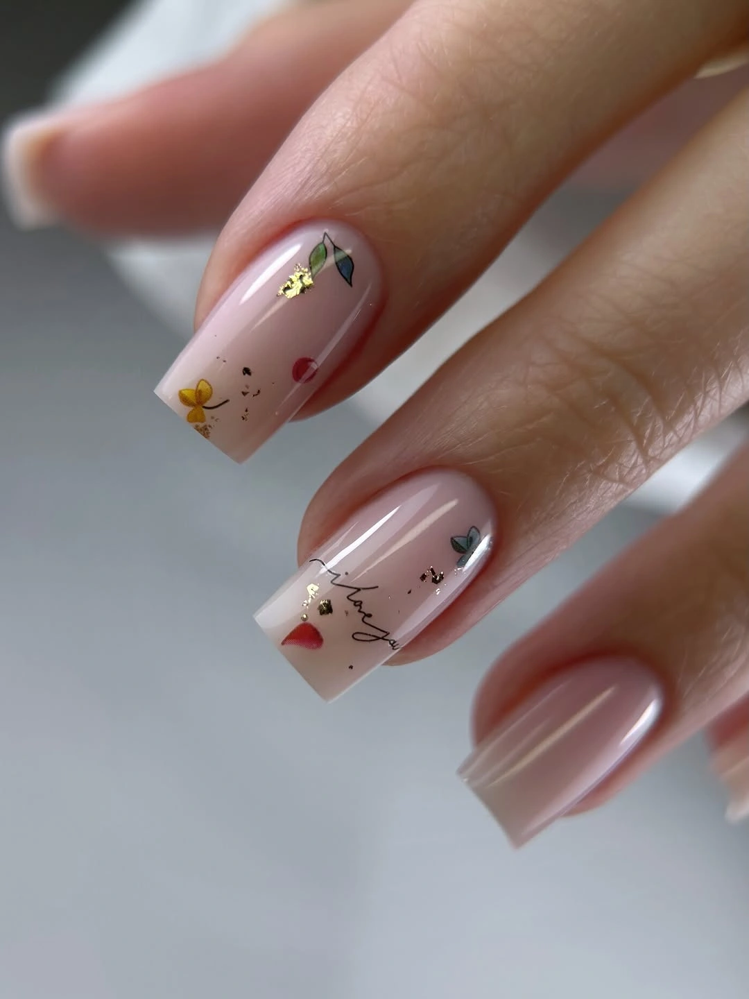 Nude square nails with tiny flowers and colored flecks