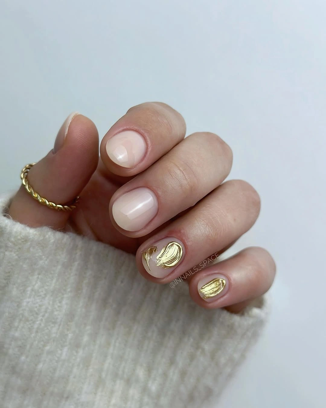 Nude short nails with raised-looking gold swirl accents