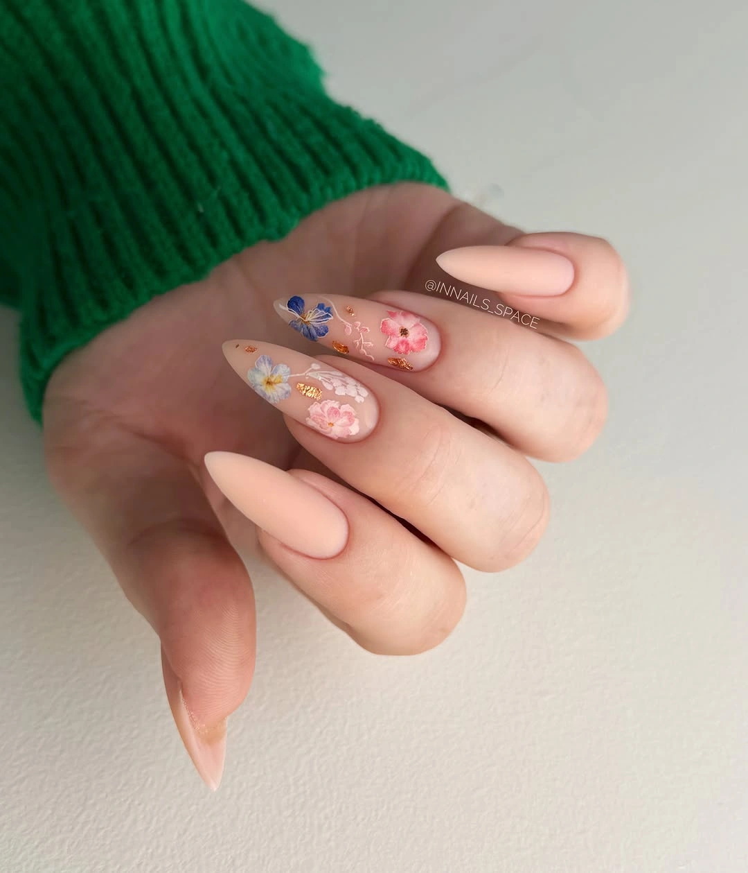 Nude almond nails with small blue and red flowers