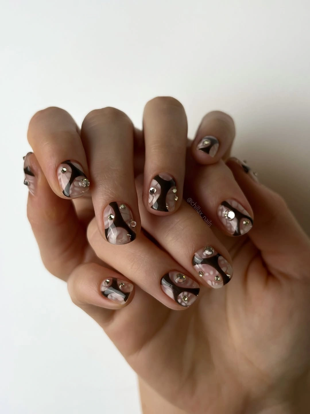 Short brown abstract nails with reflective metallic accent pieces