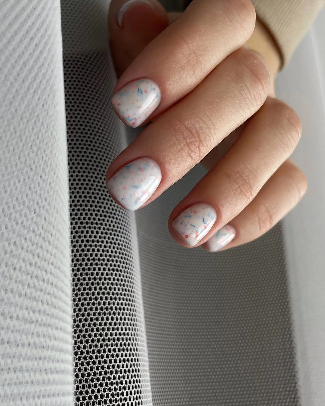 White short nails with tiny blue and red color flecks