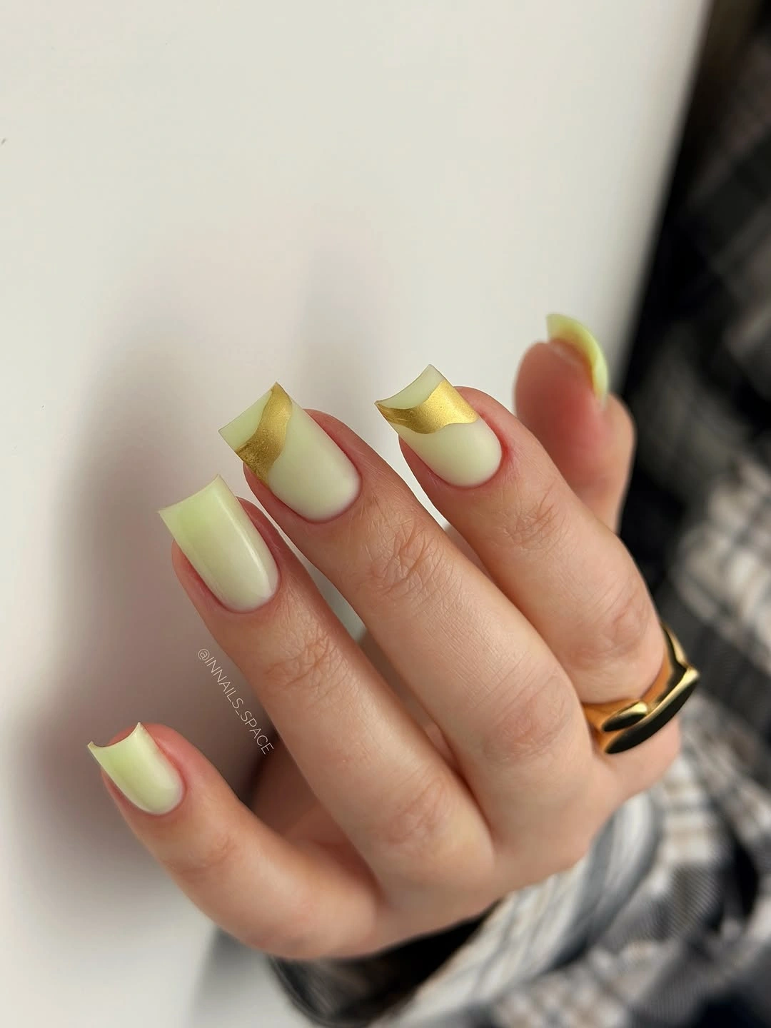 Pale yellow square nails with shiny gold French tips