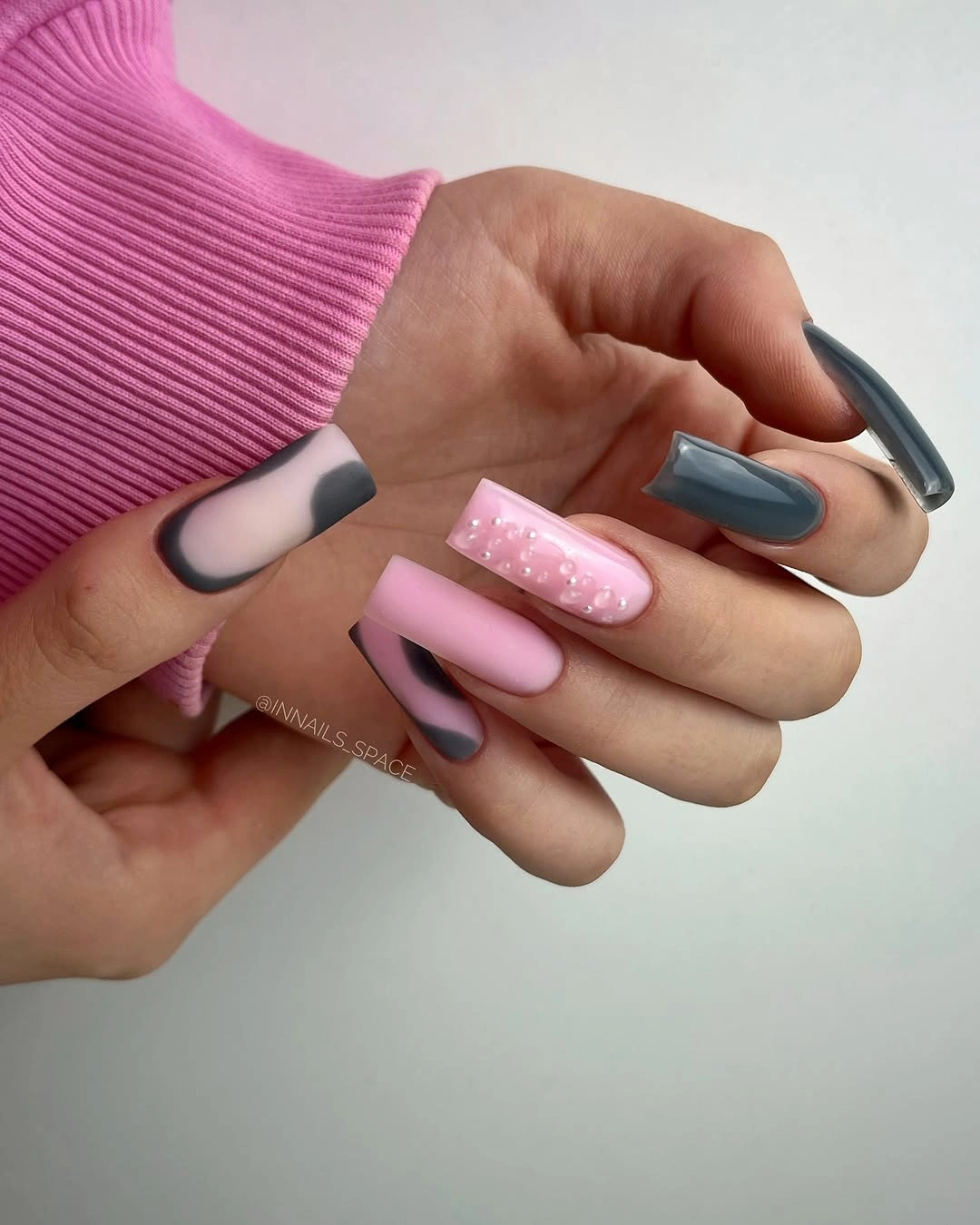 Pink and gray almond nails with soft glitter accent