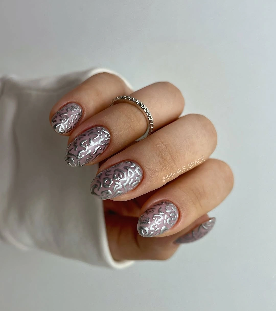 Short silver nails with raised ornamental surface detail