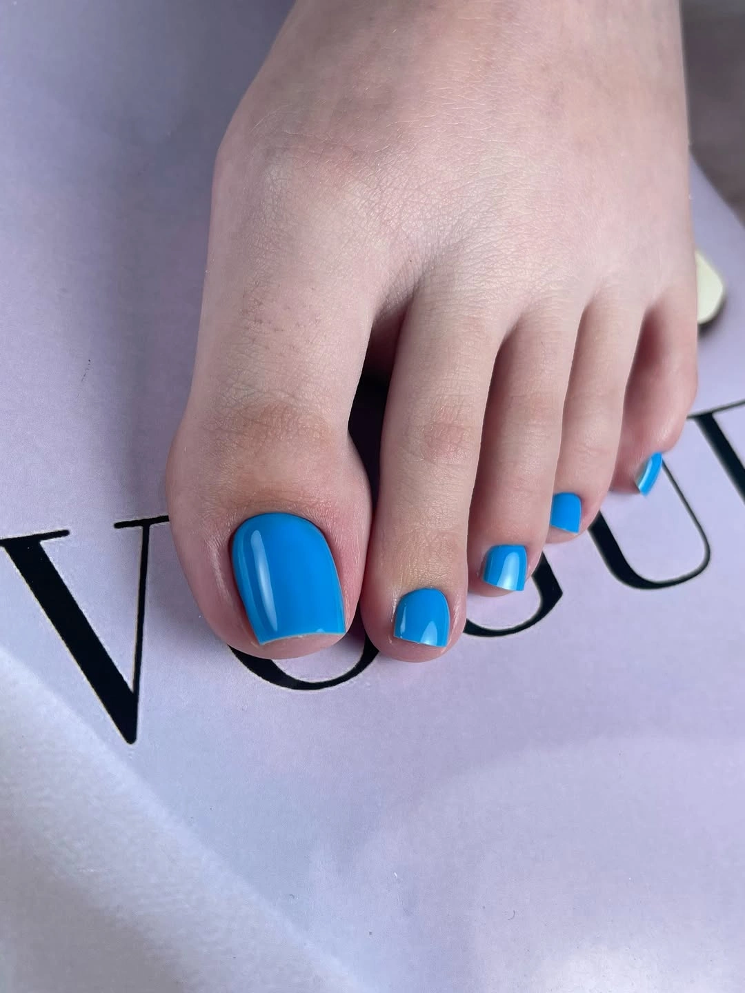 sky blue polish on short square toenails