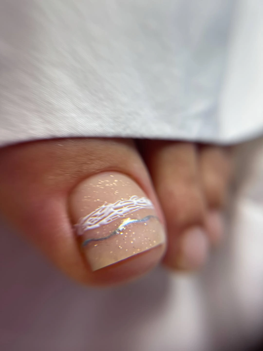 nude shimmer toenail with white line art detail