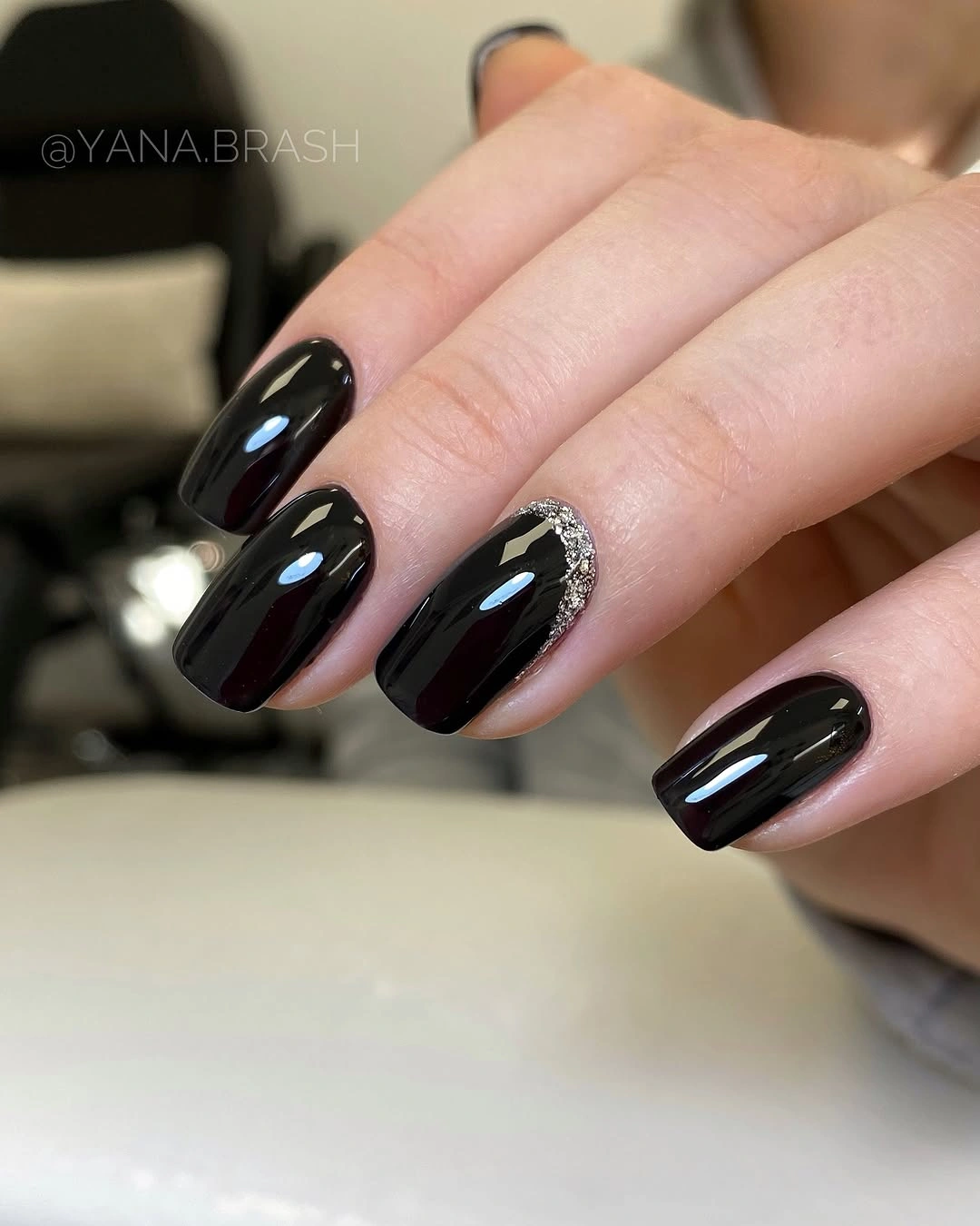 glossy black short nails with tiny pale accent