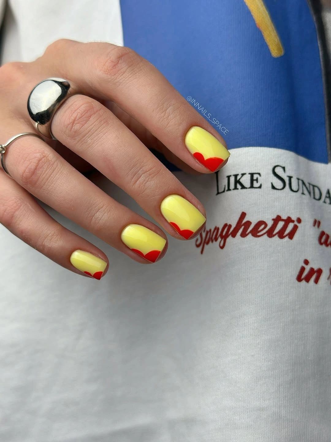 yellow short nails edged with red curved tips