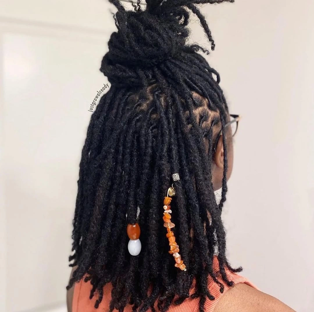 locs hairstyles for black women Half-Up Loc Bun with Natural Beads and Tribal Accents