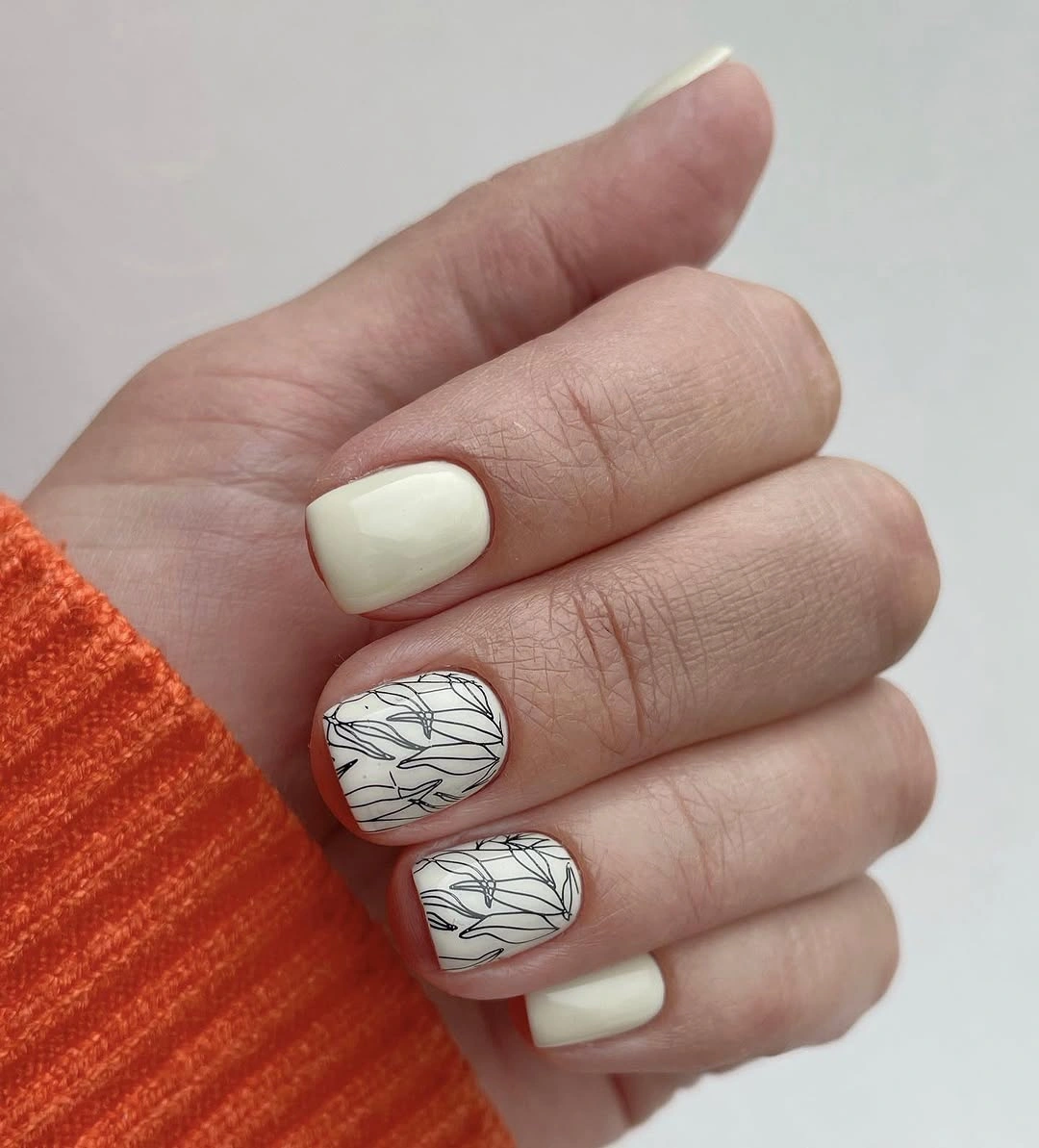 Short ivory square nails with delicate black botanical line accents