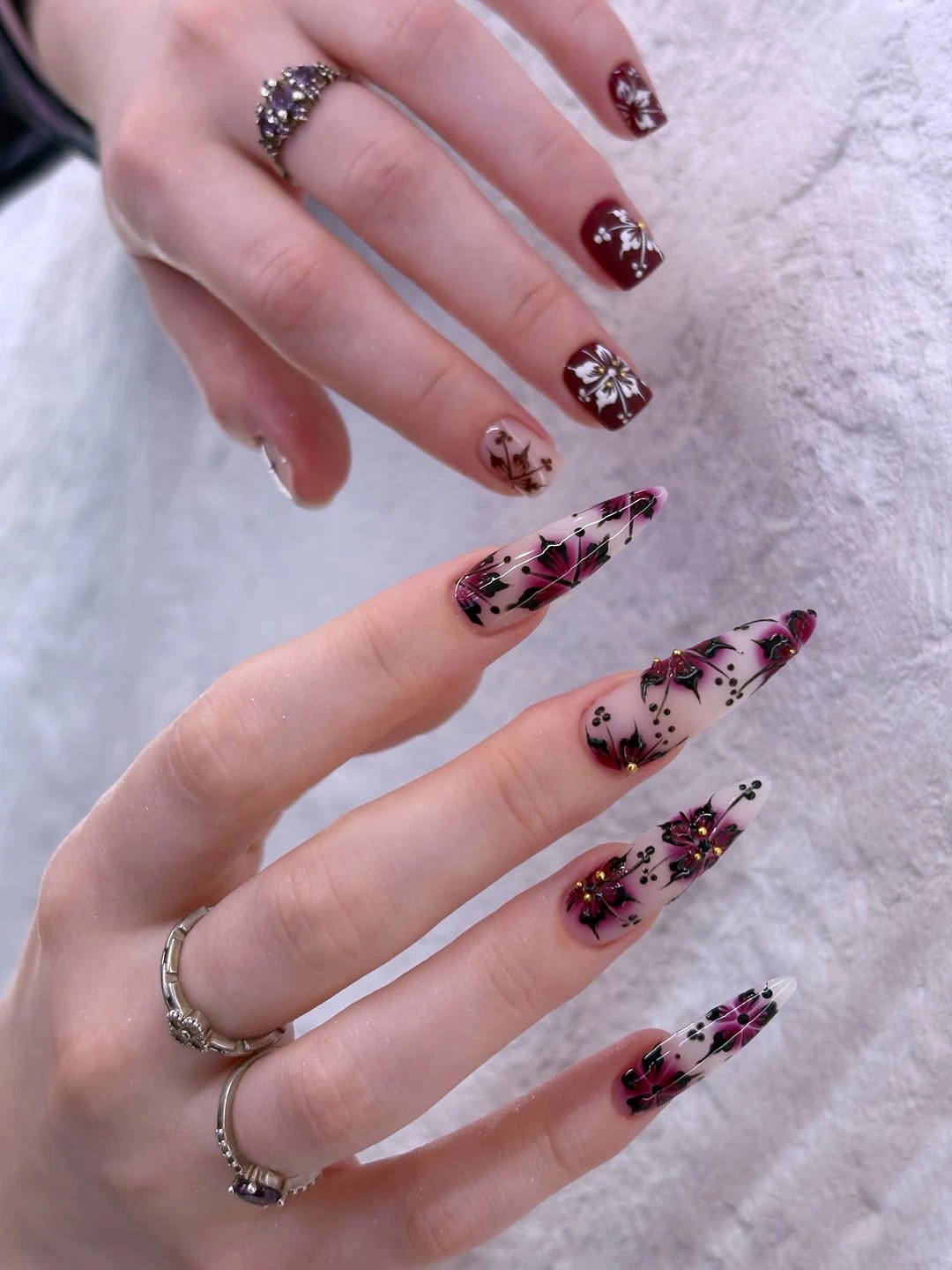 Long translucent pink nails with black magenta lines and glitter