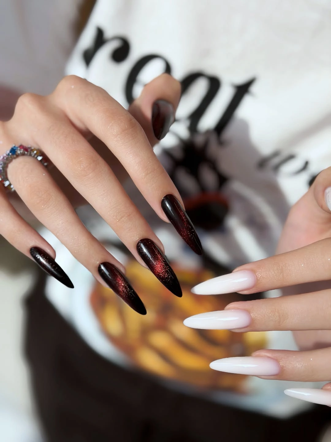 Long black pointed nails with red shimmer and white accents