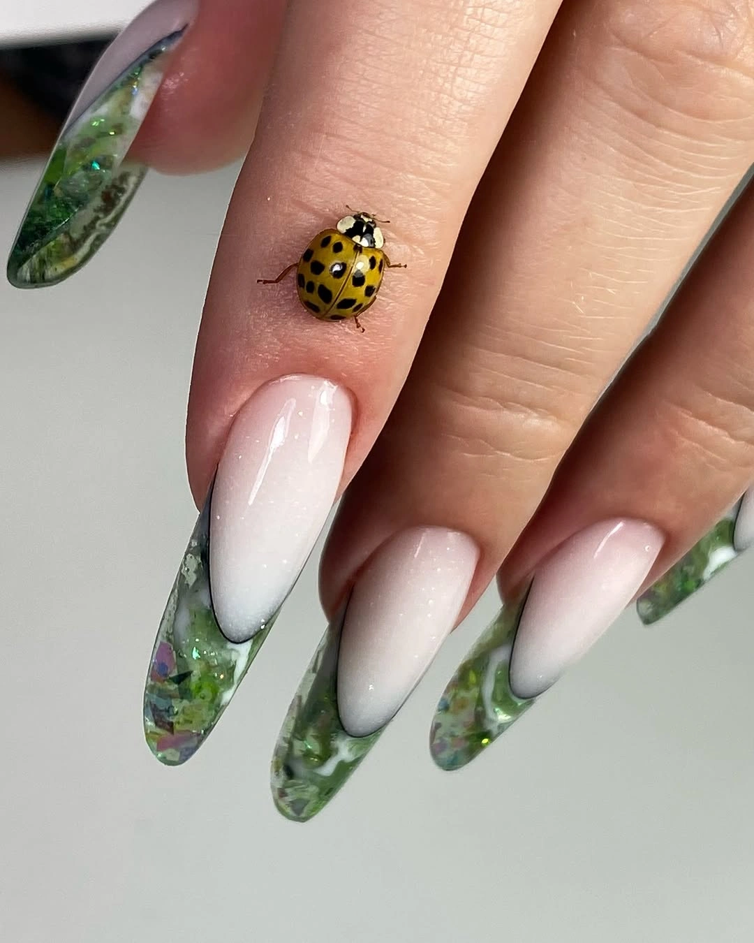 Milky almond nails with translucent green marbled tips