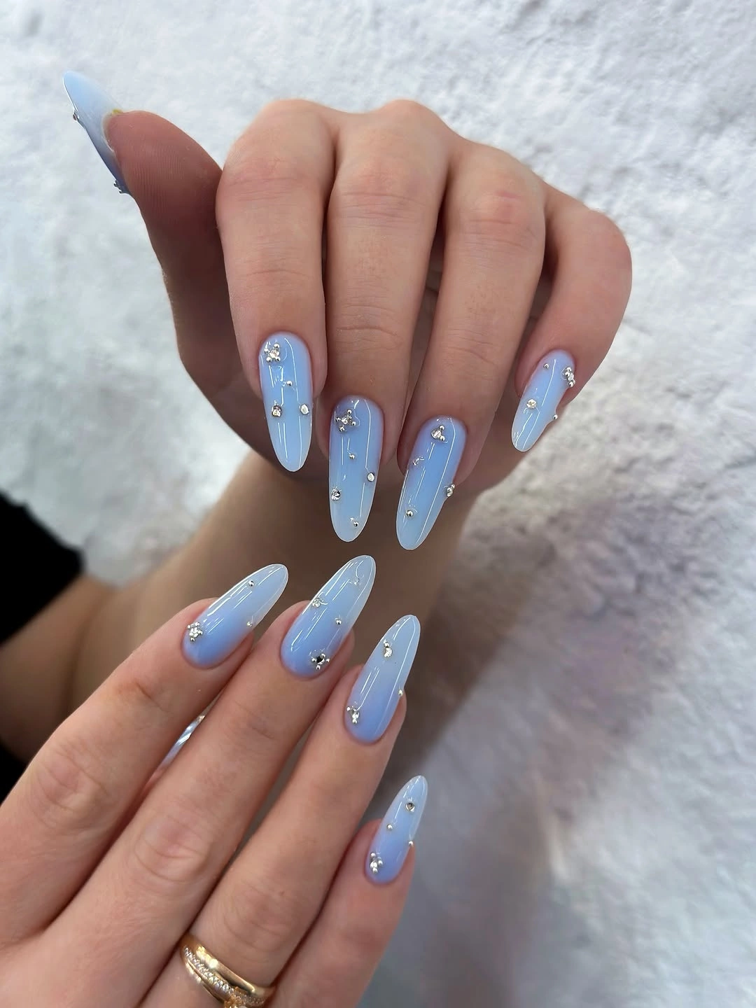 Pale blue almond nails with tiny spaced bright accents