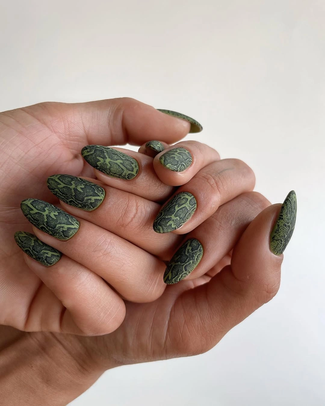 Medium almond olive nails with a dark organic pattern