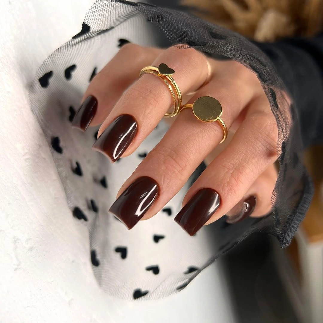 Short almond brown nails with one smoky marbled accent