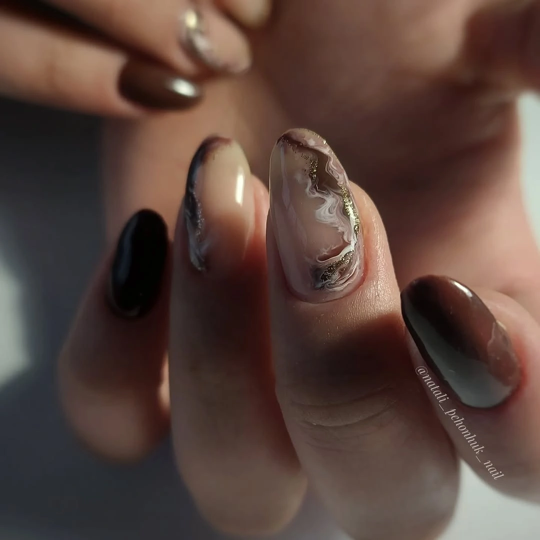 Short brown almond nails with a cream swirl accent