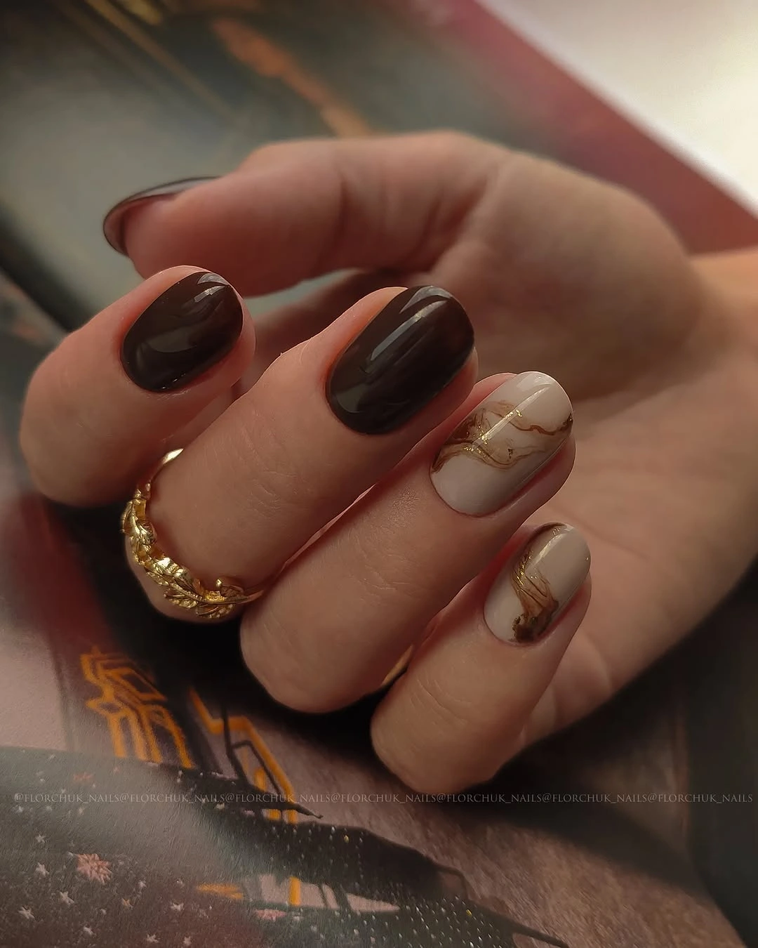 Dark square nails with small gold floral accent details