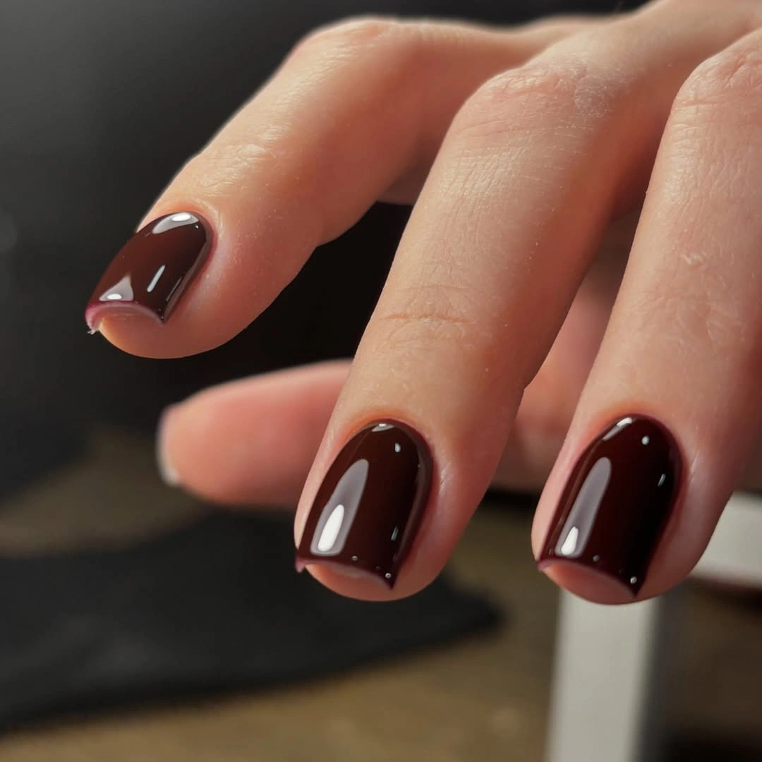 Short red brown nails with subtle pale edge details