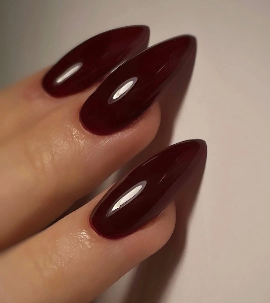 Long almond nails in glossy deep burgundy