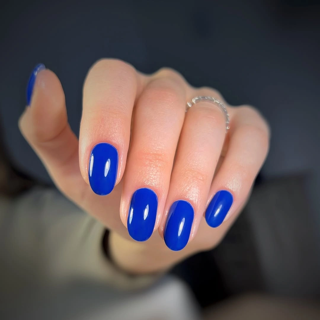 Short oval nails in saturated glossy cobalt blue