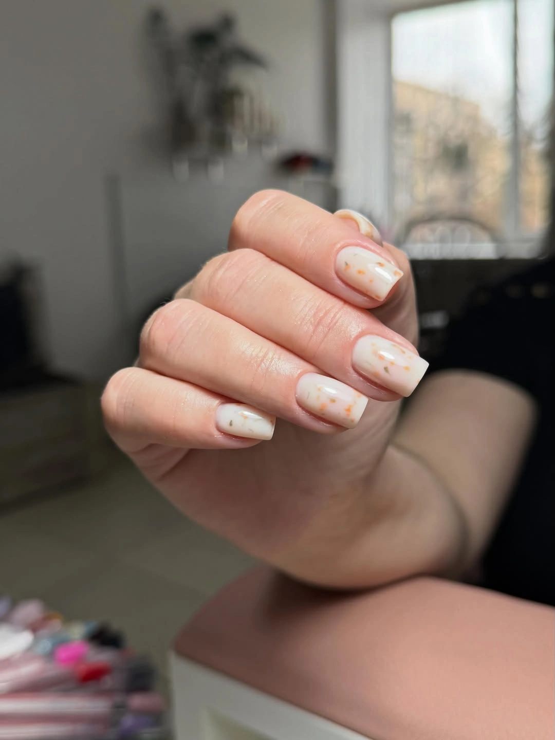 Short cream square nails with orange and green flecks