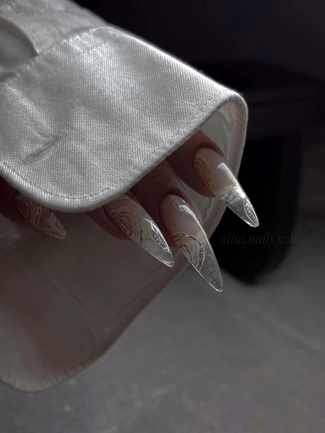 Long pointed sheer nails with silver tips and curved line art