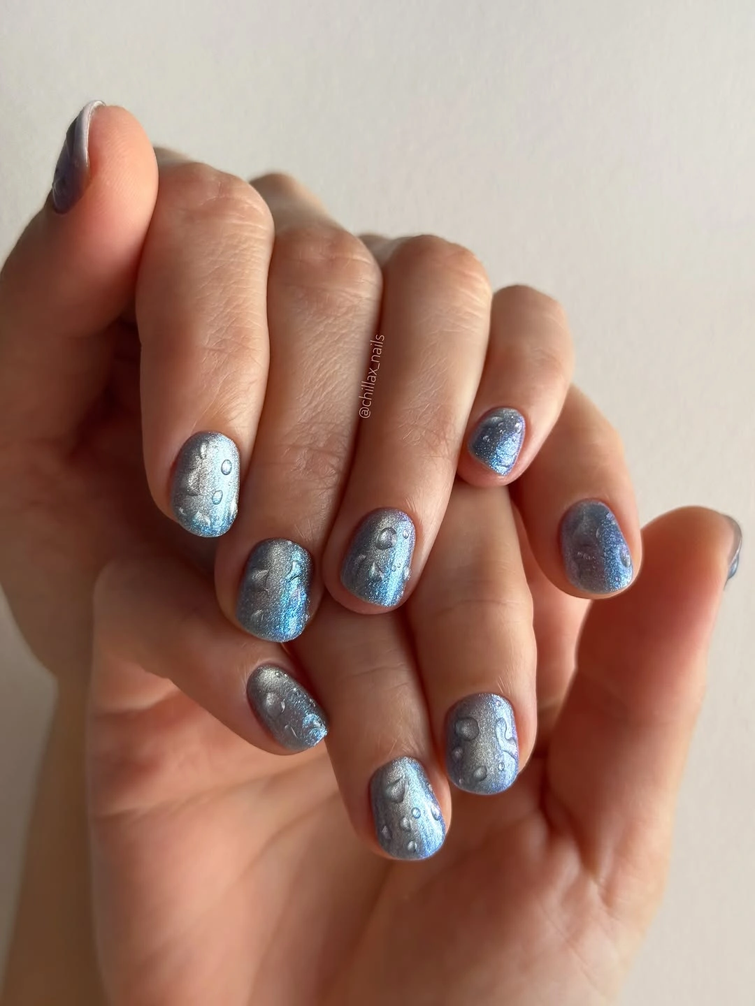Medium rounded blue nails with circular reflective accents