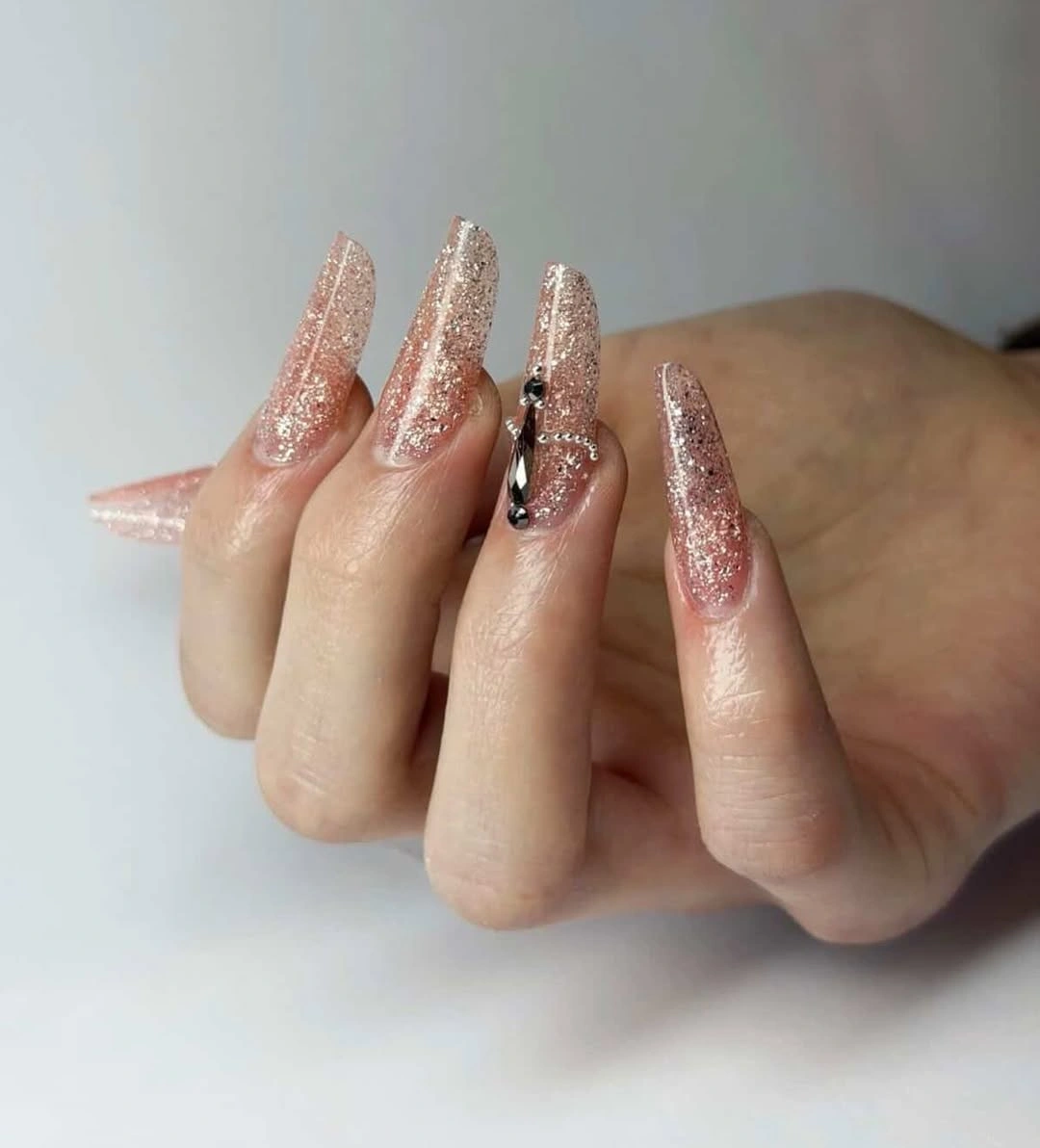 Long nude coffin nails with rose-gold glitter and focal accents