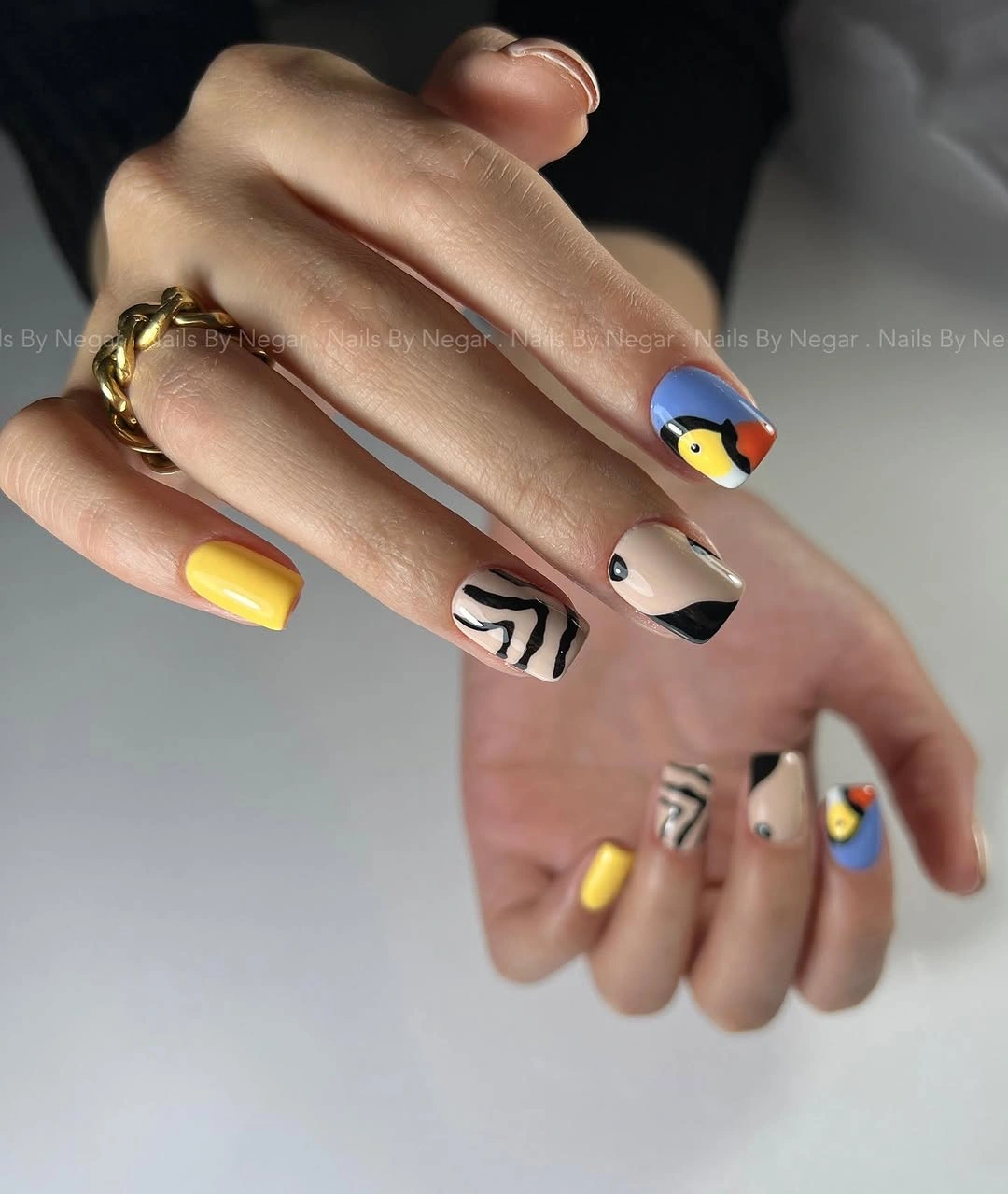 Medium square nails mixing yellow blue nude and black graphic accents