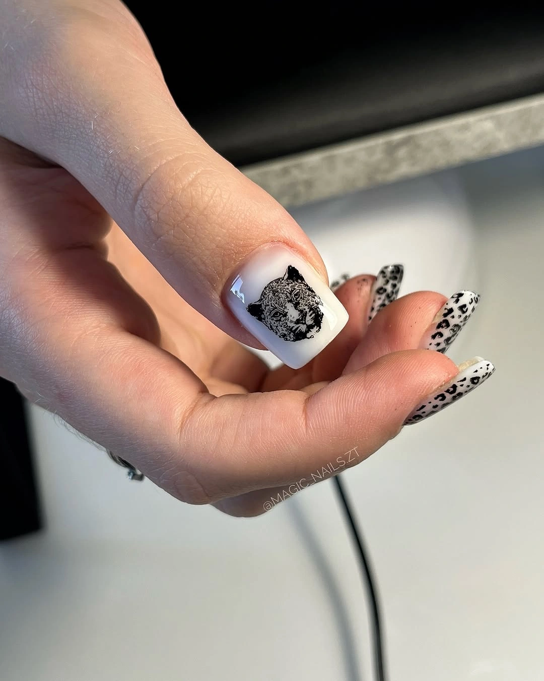Black and white animal print nails with cat accent