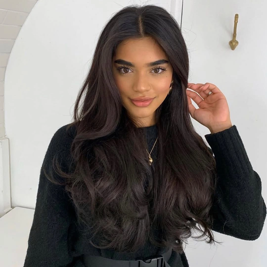 Very long centrally parted dark brown waves with faint warm ribbons