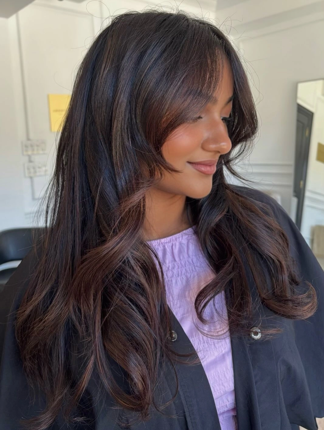 Long side-swept brown layers with warm caramel pieces