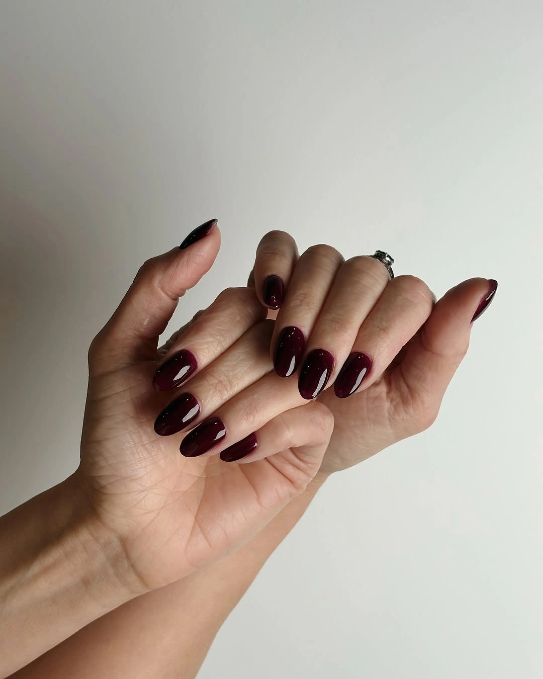 Long almond burgundy nails with a high-gloss solid finish