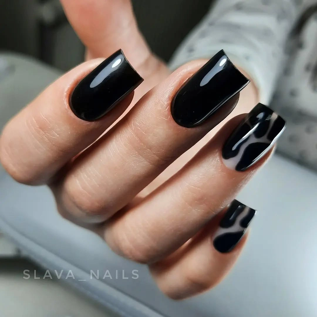 Glossy black square nails with one pale curved graphic accent