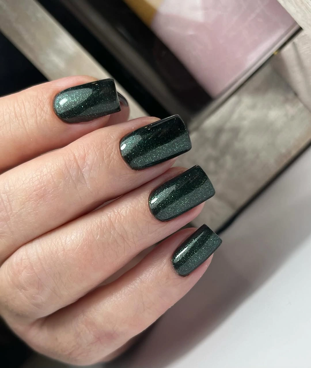 Medium square forest-green nails with fine reflective shimmer